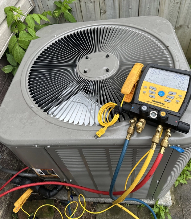 The image shows a Fieldpiece SM380V (or similar SM382V) 3-Port Wireless Refrigerant Manifold being used to service an air conditioning unit.